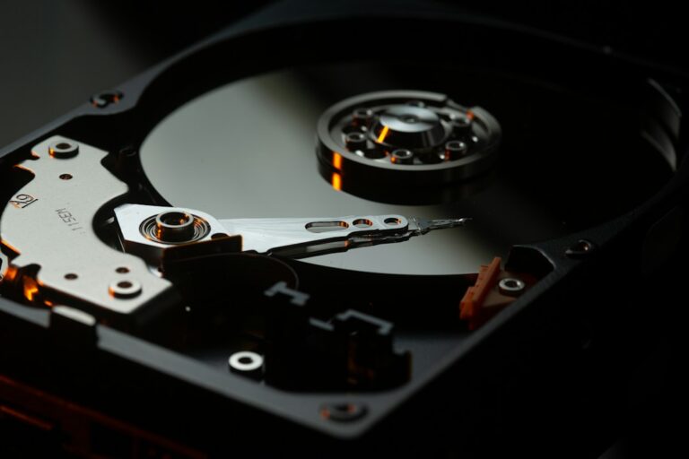 An open hard drive beside a laptop, representing files that need to be recovered