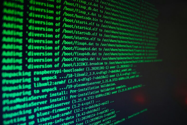 A laptop screen filled with code and a red warning graphic, representing a virus infection